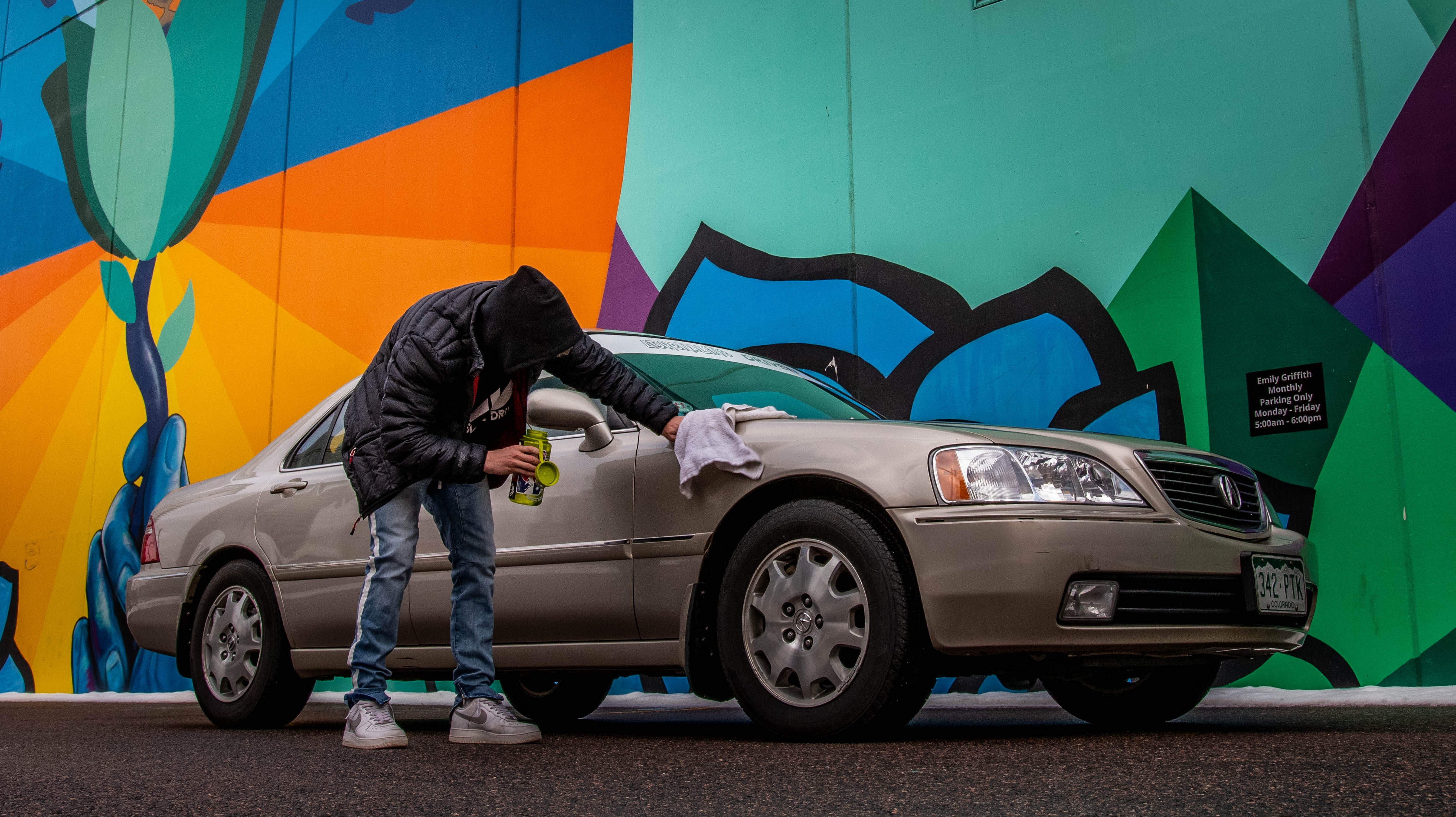 Mann putzt Auto mit Lappen